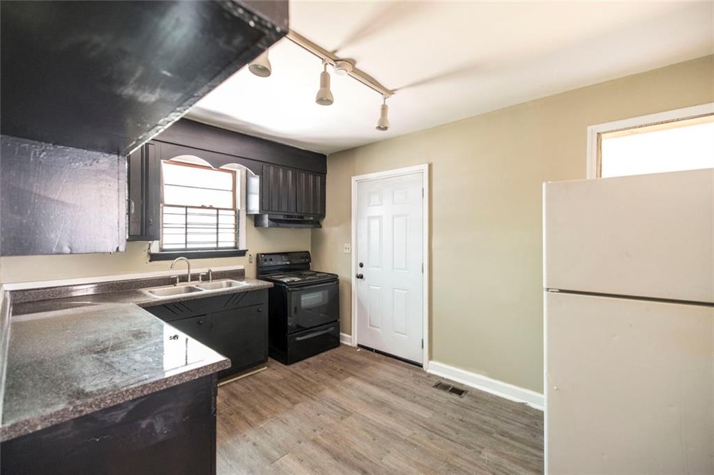 3260 Toole Drive Macon, GA 31204 - Photo 12 of 26 a kitchen with stainless steel appliances granite countertop a refrigerator a sink dishwasher a stove and white countertops with wooden floor