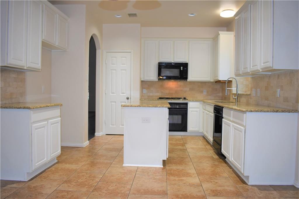 3821 Sandlin Street Grapevine, TX 76092 - Photo 14 of 26 a large kitchen with cabinets and stainless steel appliances