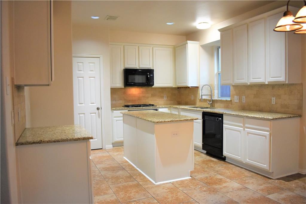 3821 Sandlin Street Grapevine, TX 76092 - Photo 15 of 26 a kitchen with granite countertop a sink stove and refrigerator