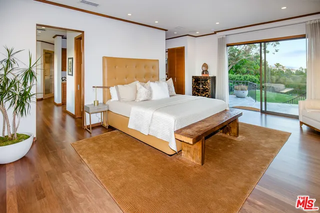 a spacious bedroom with a bed and a large window