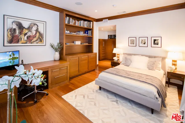 a bedroom with a bed and furniture on the wall