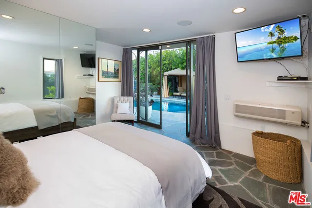 a bedroom with a bed a flat screen tv and a couch