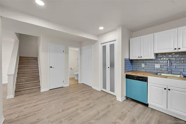 a kitchen with granite countertop white cabinets and white appliances