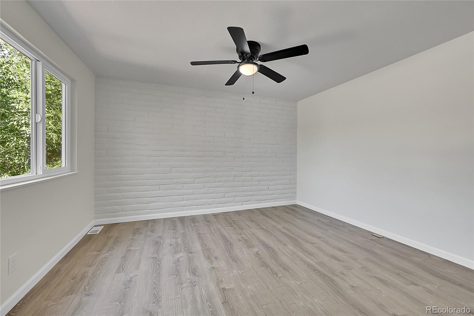 1130 South Clinton Street, Unit 68 Denver, CO 80247 - Photo 11 of 18 wooden floor in an empty room with a window