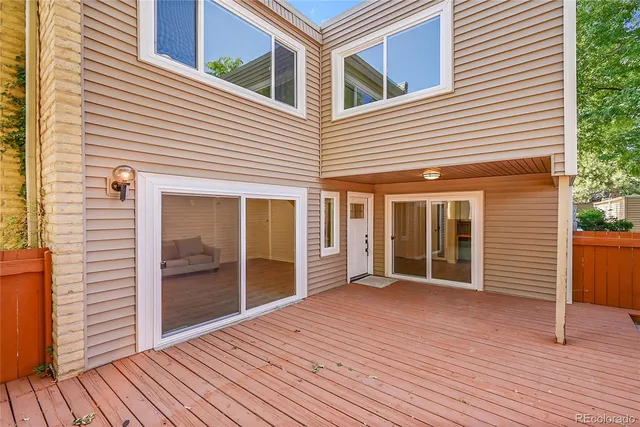 a view of a house with deck and floor to ceiling windows