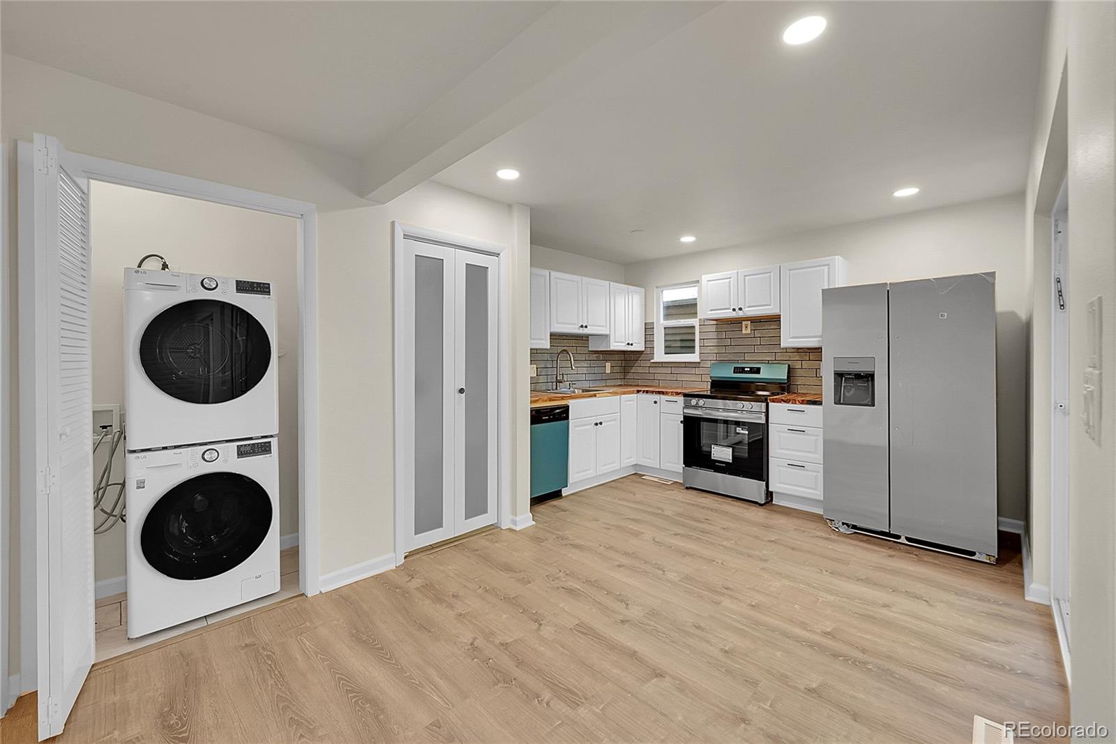 1130 South Clinton Street, Unit 68 Denver, CO 80247 - Photo 2 of 18 a kitchen with stainless steel appliances a refrigerator sink and cabinets
