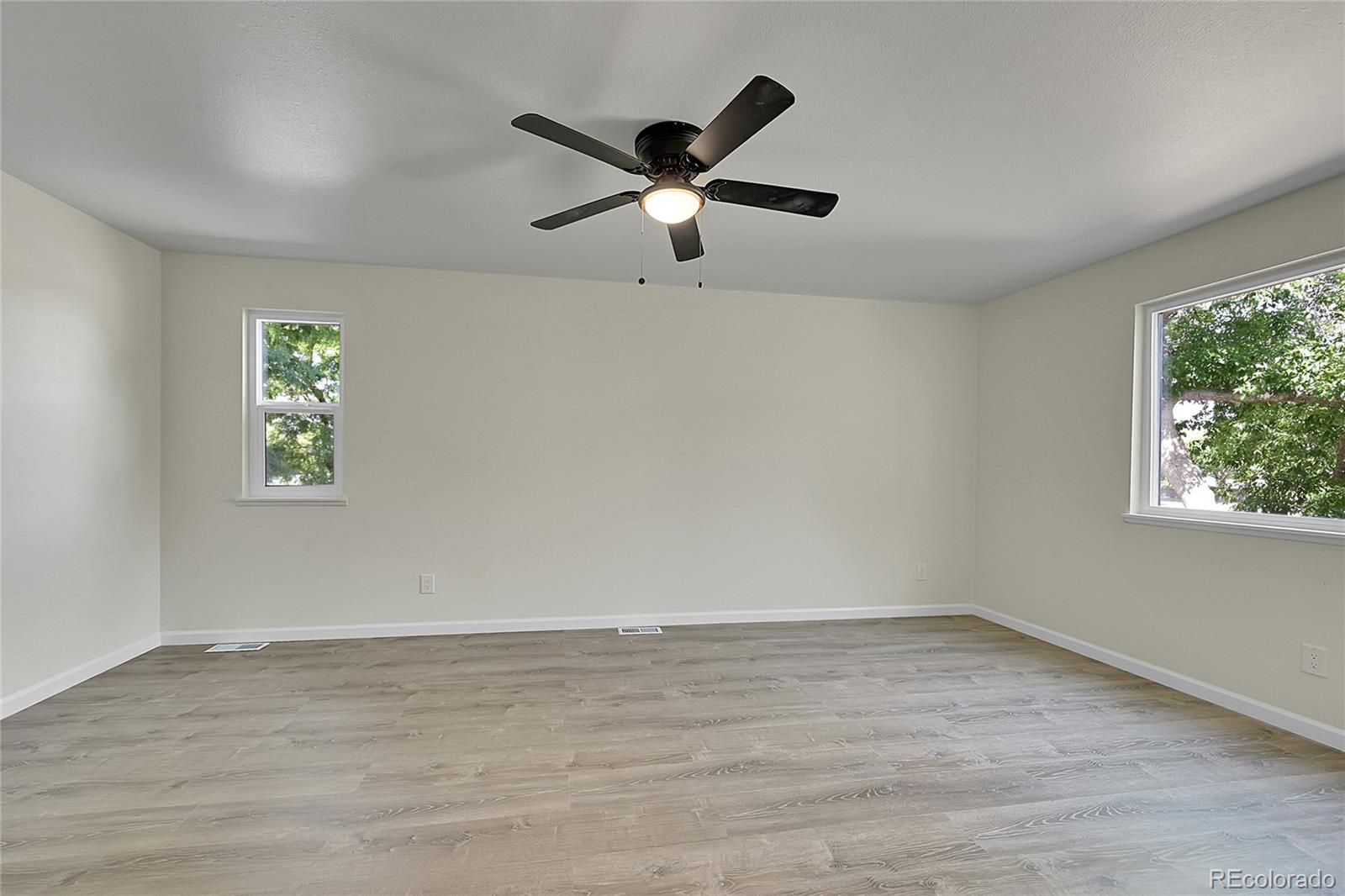 1130 South Clinton Street, Unit 68 Denver, CO 80247 - Photo 8 of 18 an empty room with wooden floor and windows