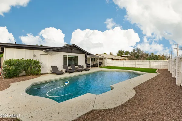 a view of a house with swimming pool and yard