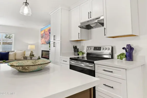 a kitchen with stainless steel appliances kitchen island granite countertop white cabinets and white appliances