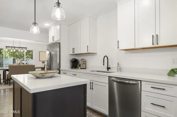 a kitchen with kitchen island granite countertop a sink cabinets and window
