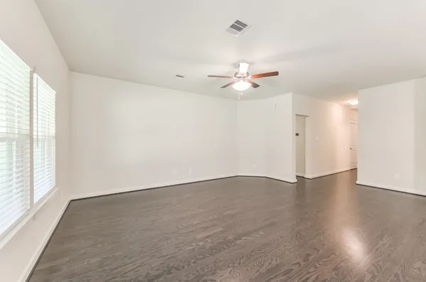 an empty room with wooden floor and window