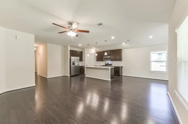 a view of an empty room with kitchen appliances and a window