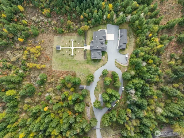 an aerial view of residential houses with outdoor space and trees