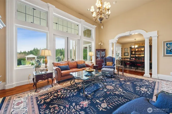 a living room with furniture large window and wooden floor