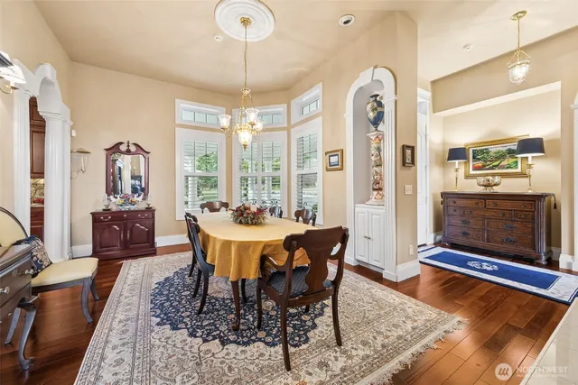 a view of a dining room with furniture a chandelier and wooden floor