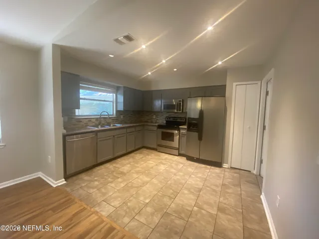 a kitchen with stainless steel appliances granite countertop a refrigerator and a sink