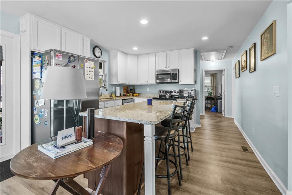 2444 Constance Street Atlanta, GA 30344 - Photo 14 of 39 a kitchen with stainless steel appliances granite countertop a dining table chairs refrigerator and microwave