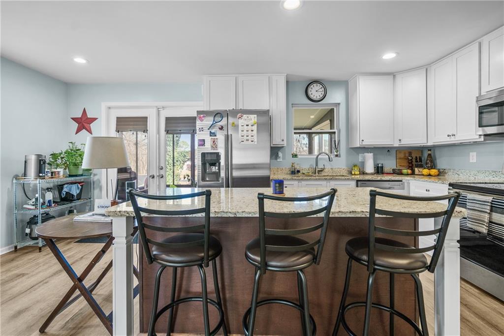 2444 Constance Street Atlanta, GA 30344 - Photo 15 of 39 a kitchen with stainless steel appliances kitchen island granite countertop a dining table chairs and a refrigerator
