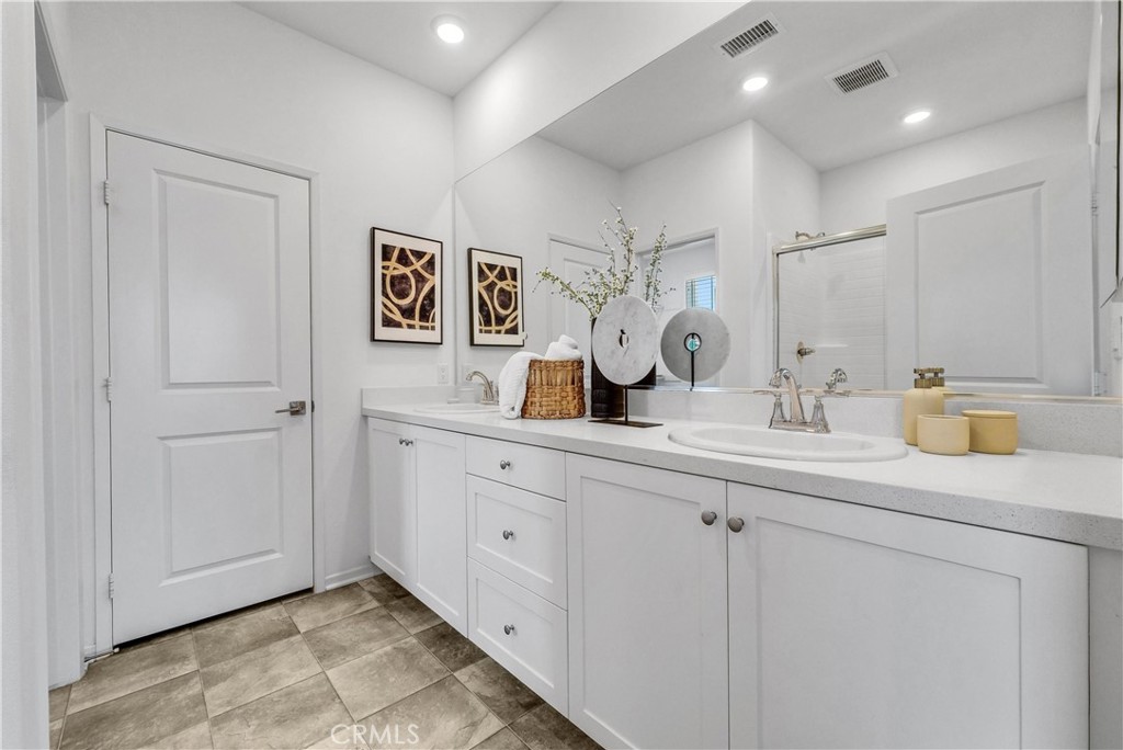 5584 Kate Way, Unit 10 Fontana, CA 92336 - Photo 16 of 42 a bathroom with a sink a mirror and a toilet