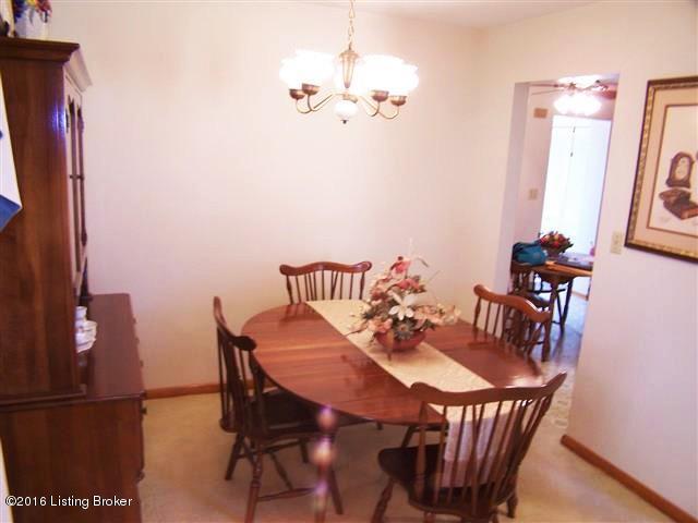 10907 Deering Road Louisville, KY 40272 - Photo 28 of 38 Dining Room with carpeting with hardwood underneath, wide open to the Living Room, new chandelier and doorway to Eat In Kitchen.