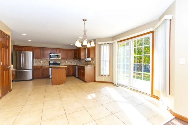 a view of a kitchen with stainless steel appliances granite countertop a stove top oven and cabinets
