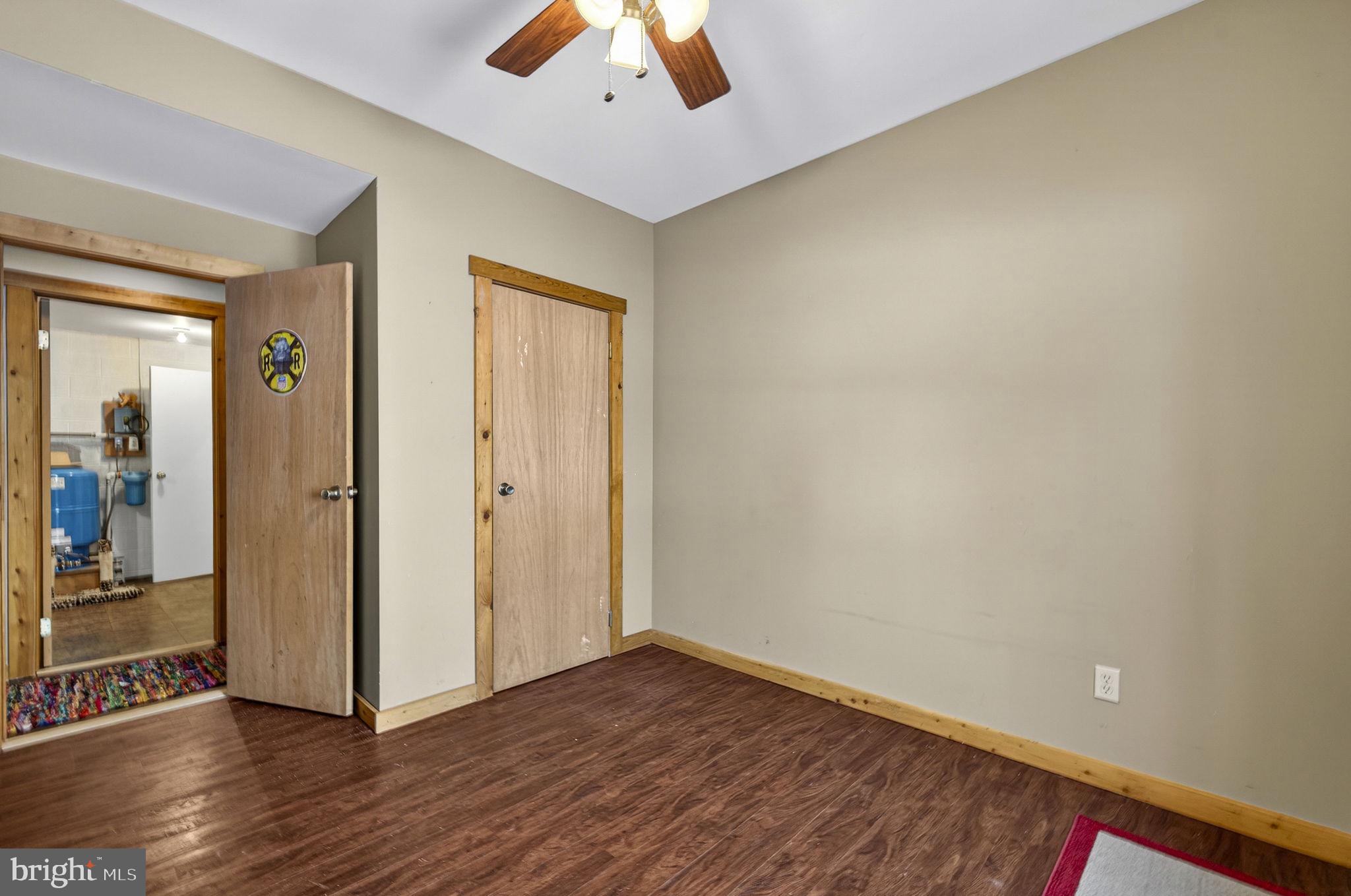 10418 Cliff Mills Road Marshall, VA 20115 - Photo 61 of 88 an empty room with wooden floor and a ceiling fan