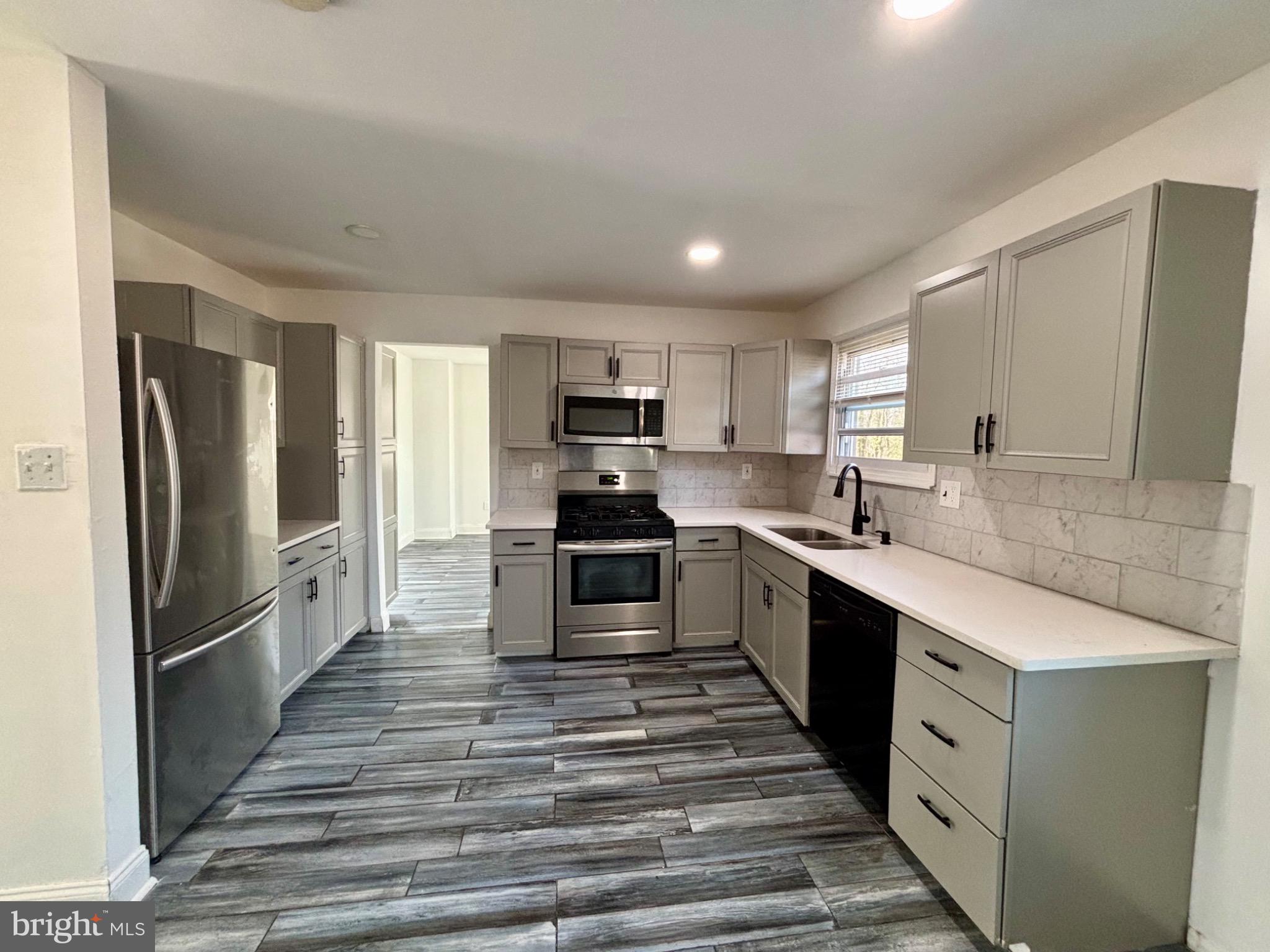142 Oak Pines Boulevard Pemberton, NJ 08068 - Photo 5 of 17 a large kitchen with cabinets stainless steel appliances and a window