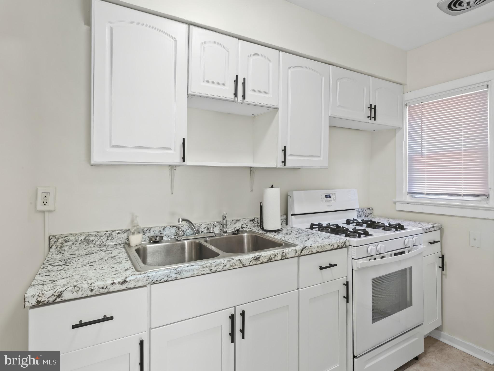 101 Upmanor Road Baltimore, MD 21229 - Photo 13 of 40 a kitchen with granite countertop white cabinets and white appliances
