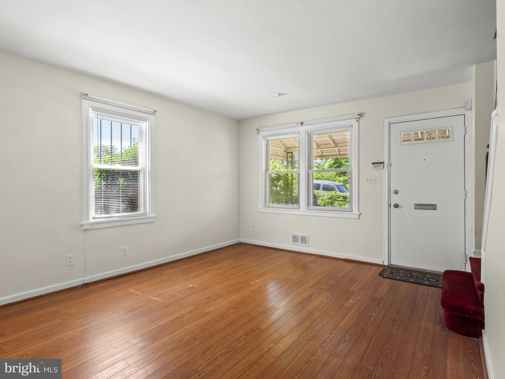 101 Upmanor Road Baltimore, MD 21229 - Photo 6 of 40 an empty room with wooden floor and windows