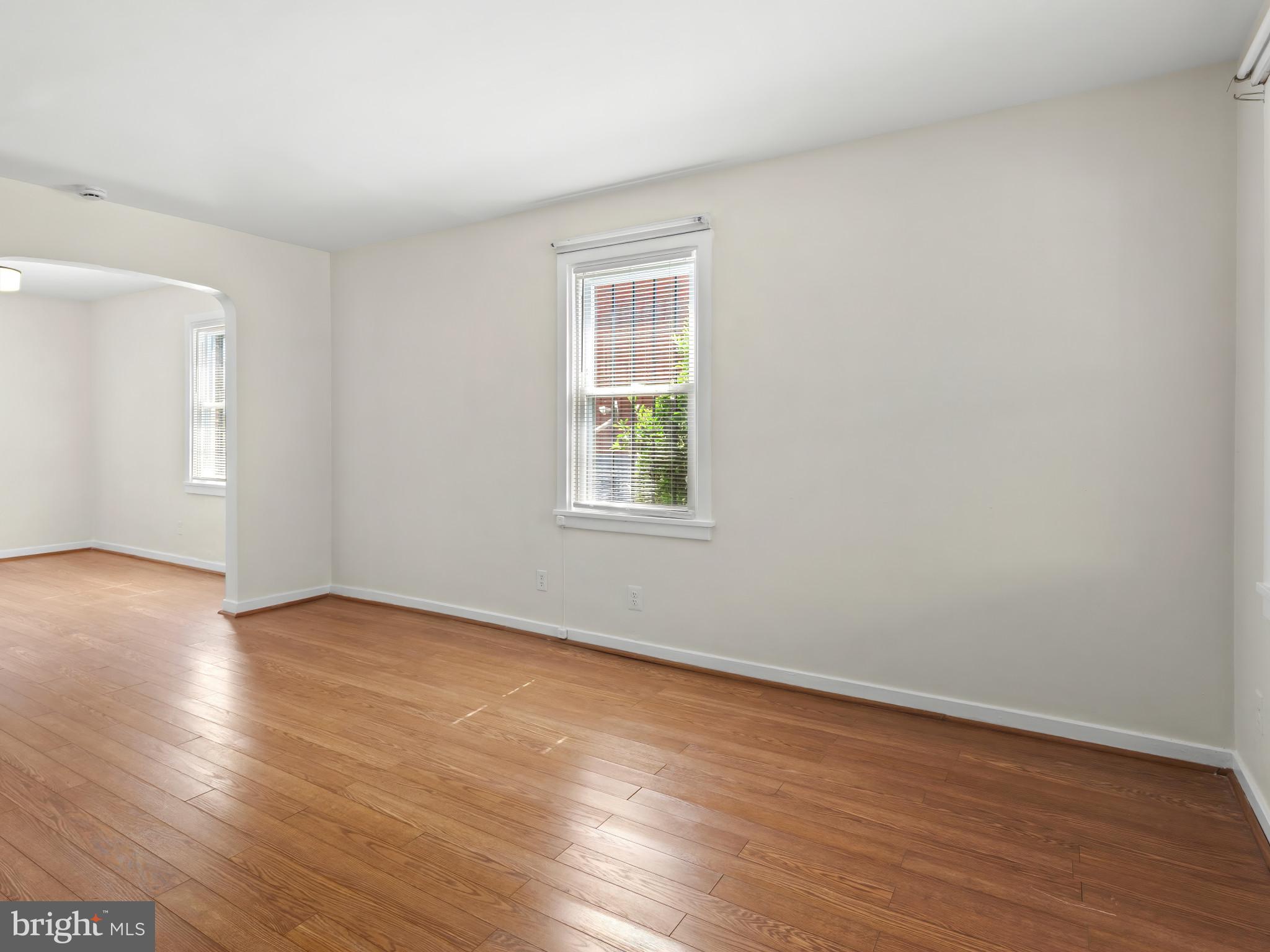 101 Upmanor Road Baltimore, MD 21229 - Photo 7 of 40 a view of an empty room with wooden floor and a window