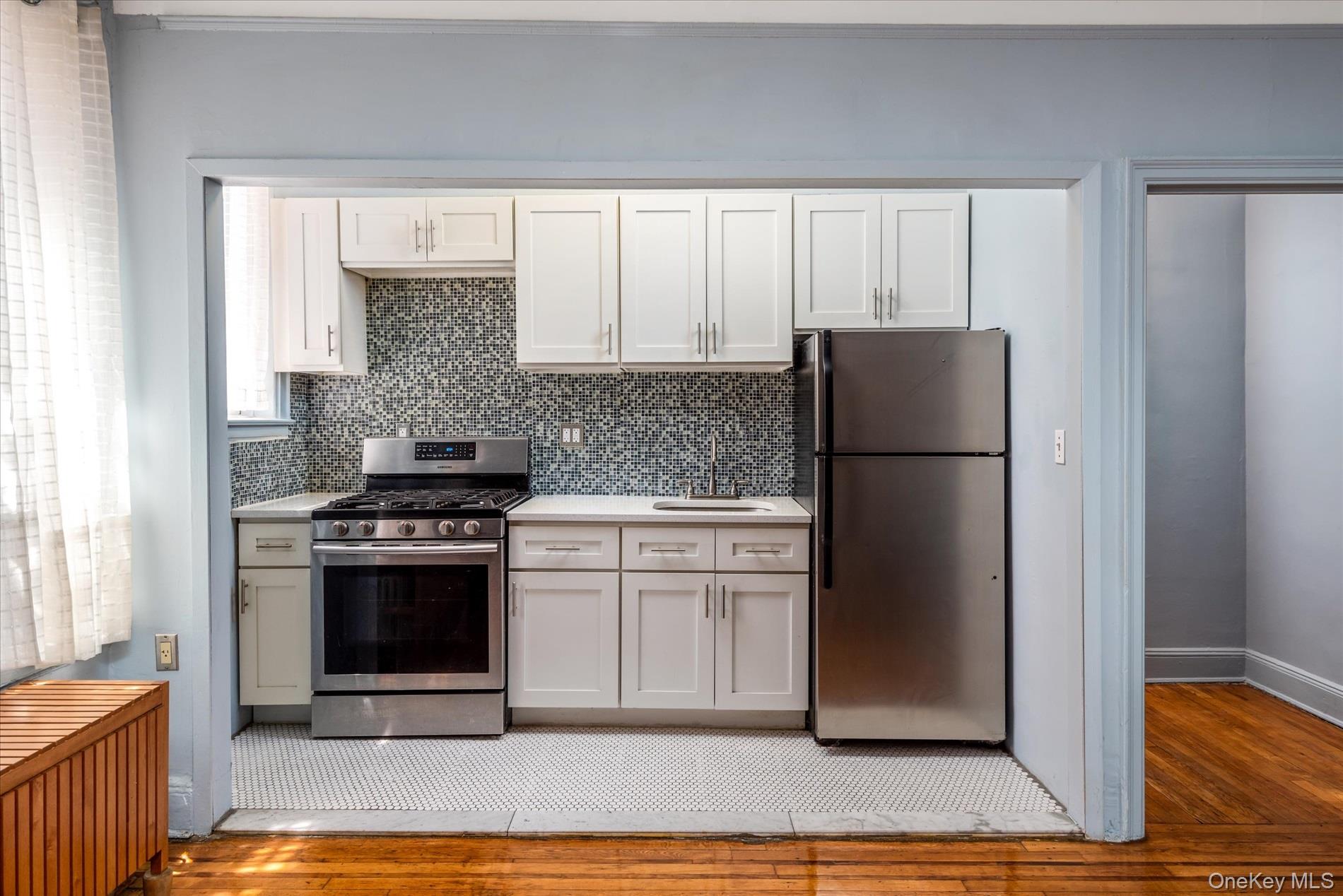 59-11 Queens Boulevard, Unit 4P Queens, NY 11377 - Photo 7 of 10 a kitchen with a refrigerator sink and cabinets