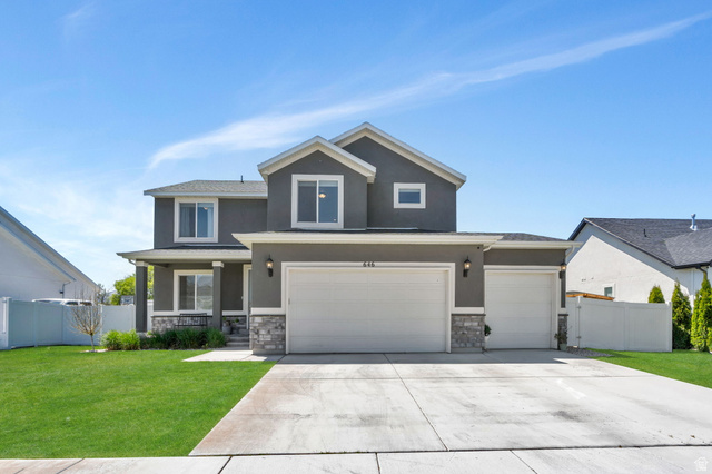646 South Meade Street Mapleton, UT 84664 - Photo 36 of 46 Two-story stucco residence featuring a covered front porch with columns, a two-car garage, an additional single-car garage, and stone veneer accents