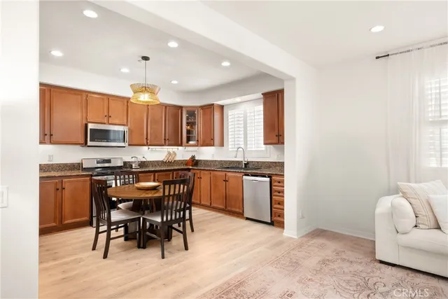 a kitchen with stainless steel appliances granite countertop a stove a sink a microwave a refrigerator and cabinets