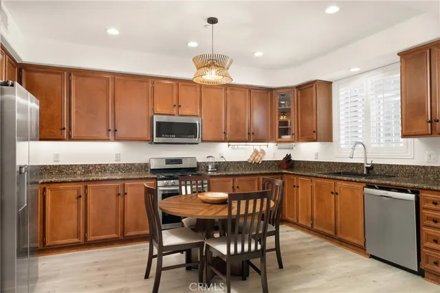 a kitchen with granite countertop a sink counter top space appliances and cabinets