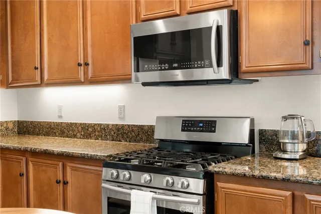 a kitchen with stainless steel appliances granite countertop a stove and a microwave
