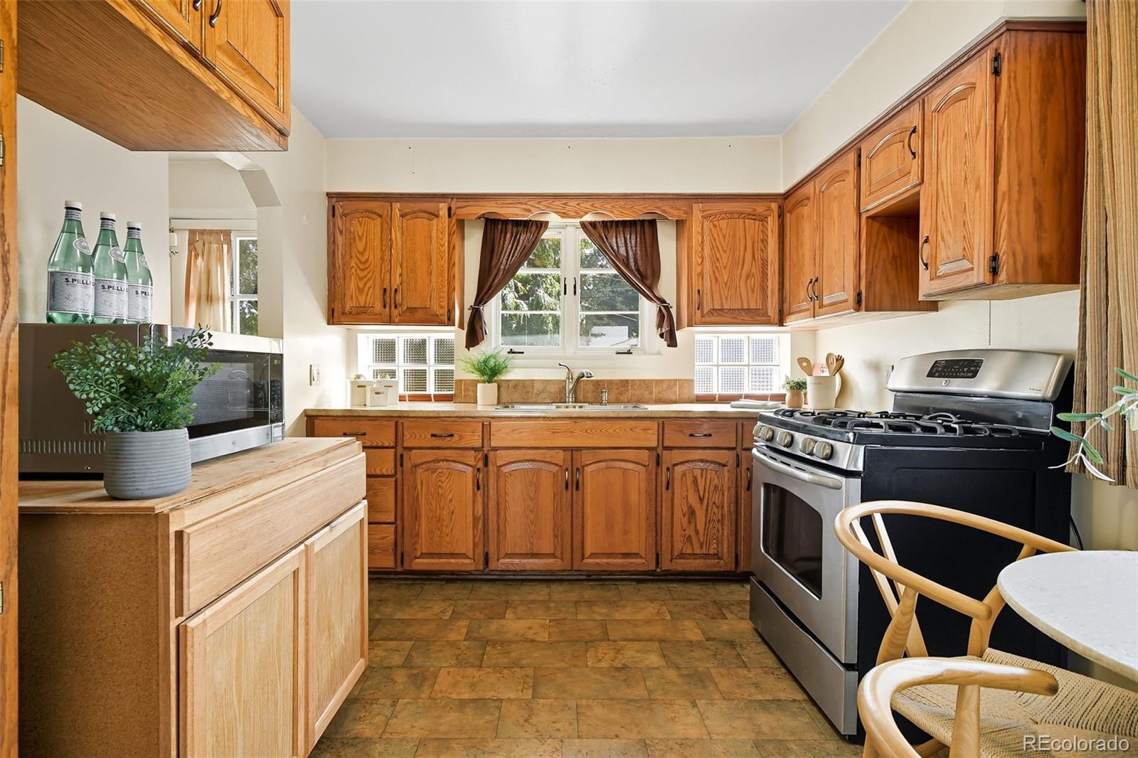 3420 Otis Street Wheat Ridge, CO 80033 - Photo 16 of 32 a kitchen with stainless steel appliances granite countertop a stove and a sink
