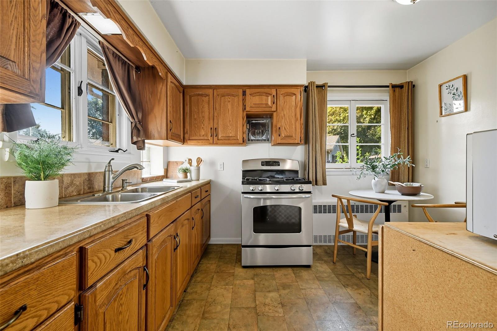 3420 Otis Street Wheat Ridge, CO 80033 - Photo 17 of 32 a kitchen with stainless steel appliances a stove a sink and a refrigerator