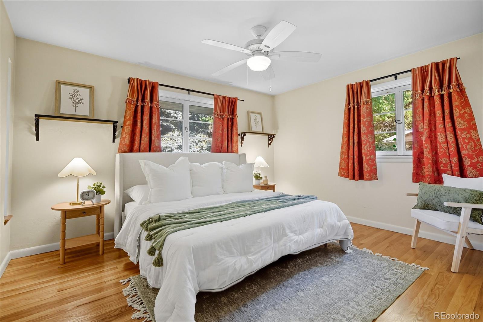 3420 Otis Street Wheat Ridge, CO 80033 - Photo 18 of 32 a bedroom with a bed and wooden floor