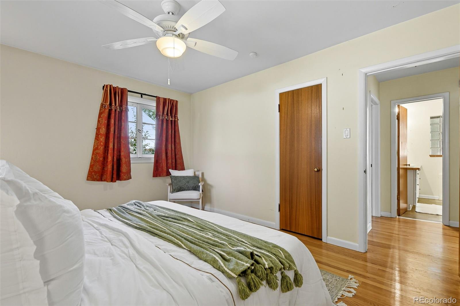 3420 Otis Street Wheat Ridge, CO 80033 - Photo 19 of 32 a bedroom with a bed and a chandelier