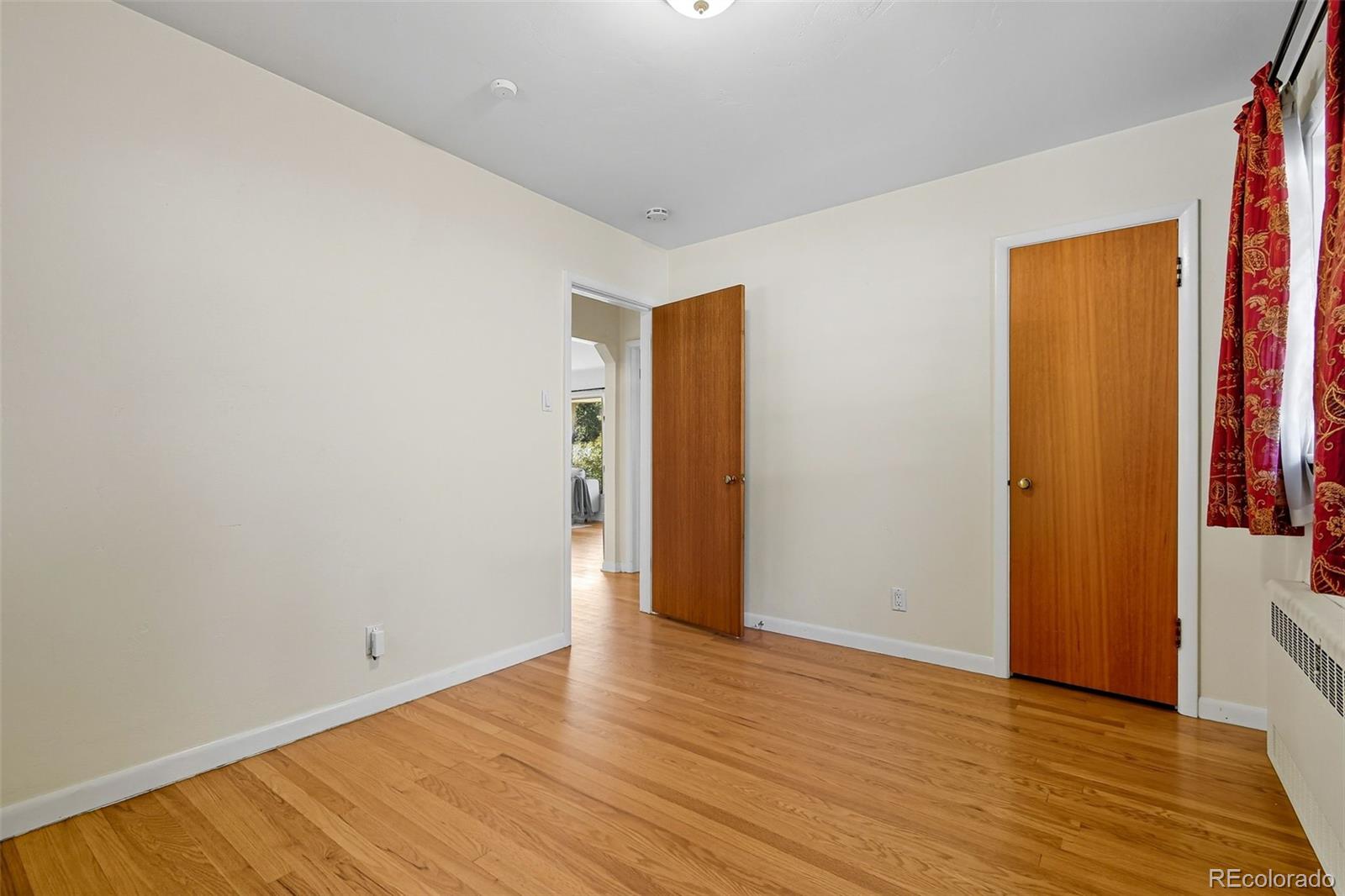 3420 Otis Street Wheat Ridge, CO 80033 - Photo 22 of 32 a view of an empty room with wooden floor and closet