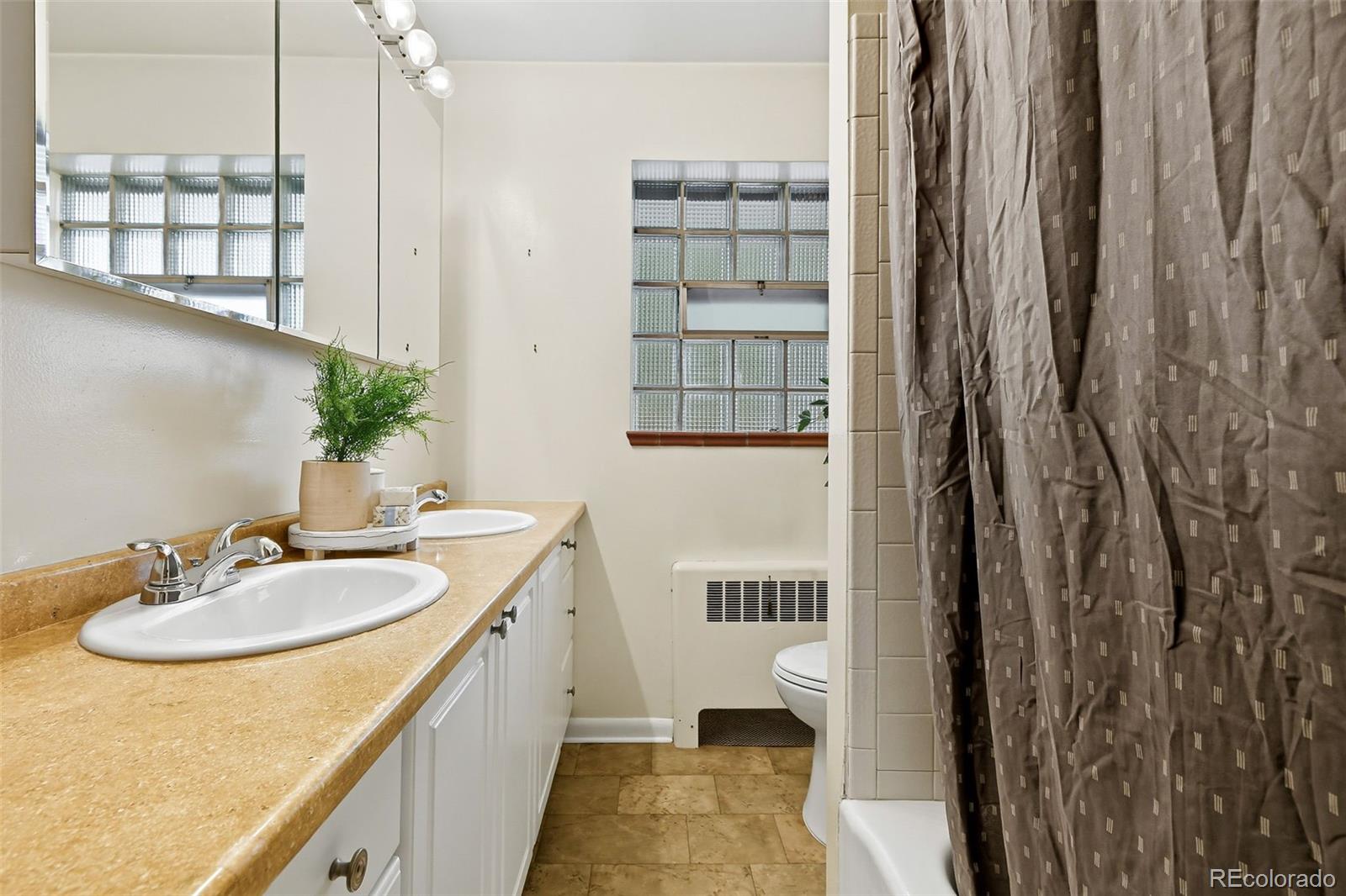 3420 Otis Street Wheat Ridge, CO 80033 - Photo 23 of 32 a spacious bathroom with a sink and a mirror
