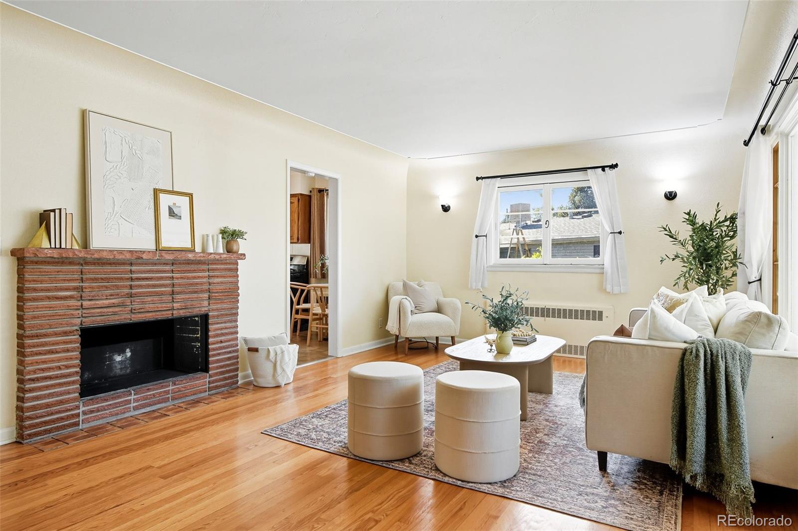 3420 Otis Street Wheat Ridge, CO 80033 - Photo 8 of 32 a living room with furniture a fireplace and a potted plant