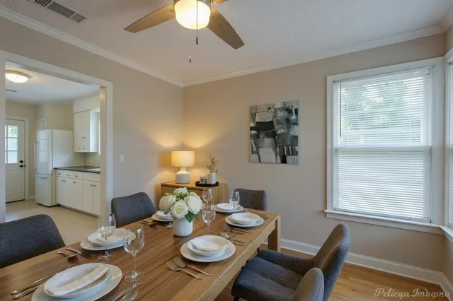 a view of a dining room with furniture a chandelier and wooden floor