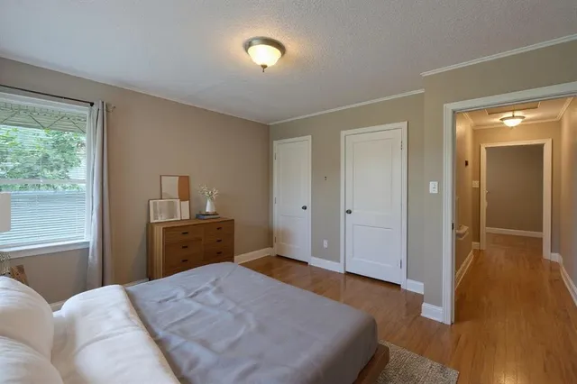 a bedroom with a bed and wooden floor
