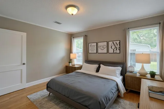 a bedroom with a bed and wooden floor