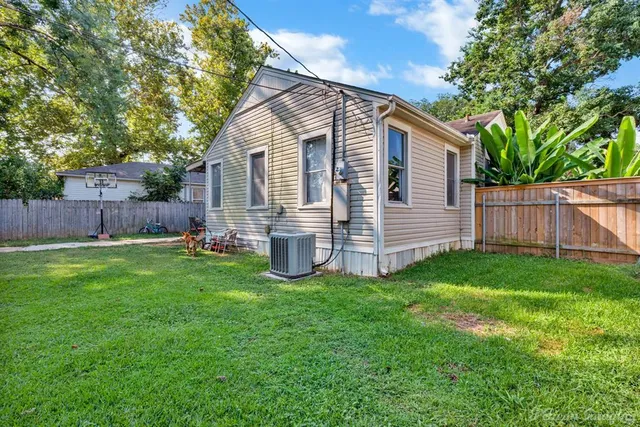 a view of a house with backyard and a tree