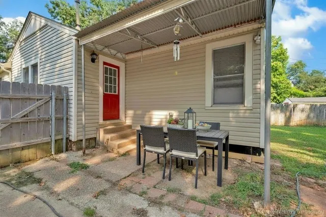 a backyard of a house with a table and chairs