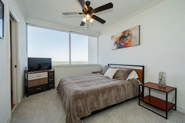a bedroom with a large bed and a chandelier