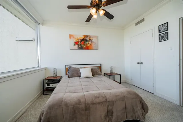 a bedroom with a large bed and a chandelier