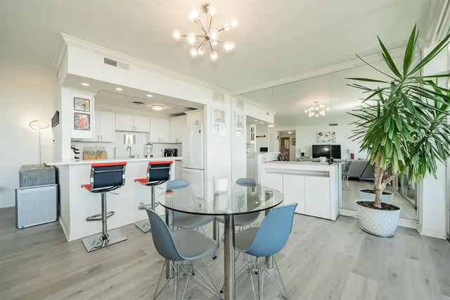 a dining room with furniture potted plants and wooden floor